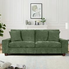 a living room scene with focus on the green couch