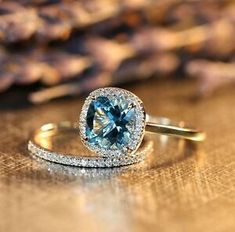 an engagement ring with a blue topazte surrounded by white and yellow gold diamonds