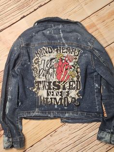 the back of a jean jacket with an image of a heart on it and words written in