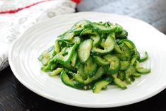 a white plate topped with cucumbers on top of a table