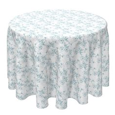 a round table covered with a white and blue flowered print fabric on an isolated background