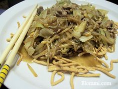 a white plate topped with noodles and chopsticks