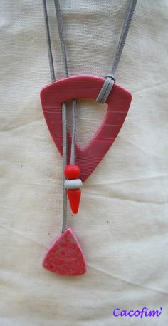 a red and white necklace hanging from a string