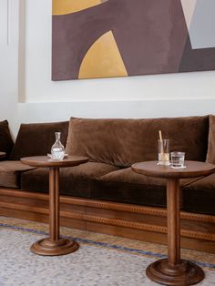 two wooden tables sitting on top of a brown couch