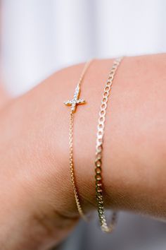 Our Esther Dainty Diamond Cross Bracelet is a glimmering beacon of faith. Stylish and elegant, this bracelet embodies the beauty of His grace. Perfect to shine on its own but sophisticated enough to add to a stack. The intentional delicacy of this design makes for the heartfelt gift of a child's first piece of fine jewelry or an adult's everyday dainty wear. Metal: 18k White Gold / 18k Yellow Gold / 18k Rose Gold Round Brilliant Cut Natural Diamonds: Approx. 0.10 ctw G Color and SI1-2 Clarity Diamonds Length: 7 inches at the longest. ﻿Adjustable sliding bead to provide options for smaller wrist size. Closure: Lobster clasp Measurements: Approx. 11.7mm length x 5.9mm width Looking for a different size? Please email us. Elegant Sterling Silver Cross Rosary Bracelet, Elegant Adjustable Cross Bracelet, Elegant Cross-shaped Rosary Bracelet For Wedding, Elegant Cross Rosary Bracelet For Wedding, Timeless Bracelets With Diamond Accents For Gift, Collar Chain, Bridal Bands, Band Bracelet, Diamond Cross