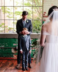 a man in a suit and tie standing next to a woman wearing a wedding dress