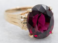 Add some sparkle to your outfit with this beautiful cocktail ring featuring an oval cut rhodolite garnet. This solitaire design will definitely turn heads and make a statement. Cheers to a touch of fun and elegance in one! Metal: 14K Yellow Gold Gem: Rhodolite Garnet 8.54 Carats Gem Measurements: 10.5 x 13.0 mm, Oval Ring Size: 7 Marks: "14K" Stamped on the inside band SKU #: A48815 Each piece has been identified and graded by a Graduate Gemologist who has been certified by the Gemological Institute of America (GIA). We have six brick-and-mortar storefronts in Maine, Massachusetts, and New Hampshire and have been in business for over 25 years! Please visit our Shop's About Page or our website for more information about our jewelry. For questions about diamond grading, we recommend the  Gem Rhodolite Garnet Ring, Oval Ring, Garnet Ring, Oval Rings, Rhodolite Garnet, Garnet Rings, Ring Ring, Cocktail Ring, New Hampshire