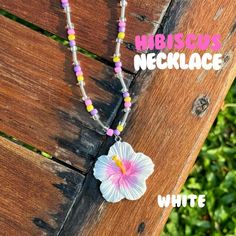 a necklace with a flower on it and the words hibiska necklace written below