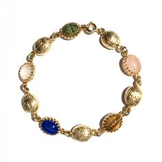 Finely detailed vintage gold gilt scarabs with hieroglyphs combine with vintage gemstone scarabs in this stunning dainty bracelet found only at Mas Collected. View all photos for close ups of the incredible detail. Makes a great gift idea for her!  Scarabs are considered to signify self transformation, new beginnings and good luck. Whether for you, or someone you love, welcome the season with our own in house designed limited quantity scarab gold filled bracelet!  Gemstone scarabs are hand set i Heirloom Gold Bracelets With Multi-stone, Heirloom Gold Multi-stone Bracelets, Gold Oval Bohemian Bracelets, Bohemian Gold Oval Bracelets, Antique Gold Bracelets With Cabochon, Antique Gold Cabochon Bracelets, Vintage Yellow Gold Bracelets With Jewels, Vintage Yellow Gold Bracelet With Jewels, Gold Oval Bracelet With Gemstone Accents