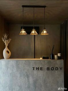 the body is sitting on top of a counter next to two lamps and a vase