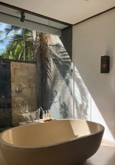 a large bathtub sitting in the middle of a bathroom next to a wall mounted shower