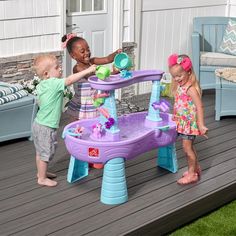 two children playing with a water table on a deck