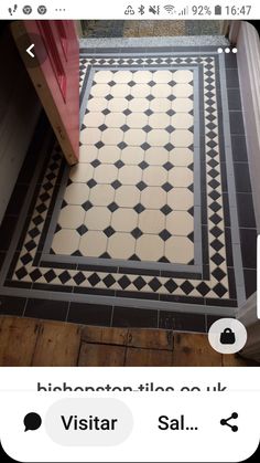 a tile floor with black and white designs on it, next to a red door