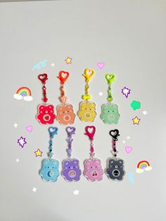 there are many bear key chains hanging on the refrigerator door with hearts and rainbows