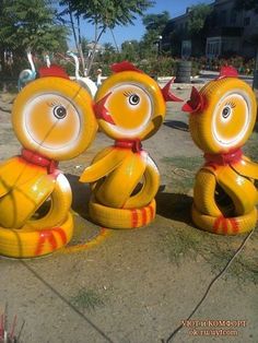 three yellow and red birds sitting on top of each other in front of a building