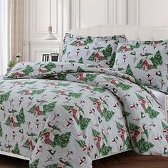 a bed with a christmas themed comforter and pillows