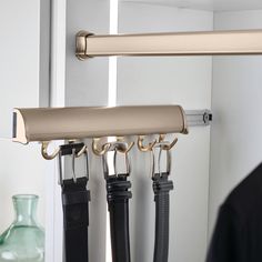 a pair of umbrellas hanging from hooks in front of a mirror with other items on it