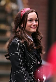 a woman in a black and white jacket smiles at the camera