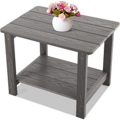 a small wooden table with flowers in a white vase on the top and bottom shelf