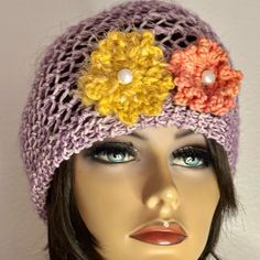 a mannequin head wearing a crocheted hat with flowers