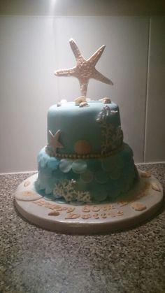 there is a blue cake with starfish on top