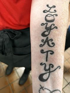 a person with a tattoo on their arm that has the word faith written in cursive writing