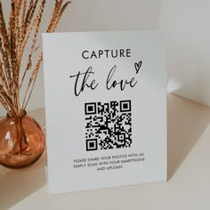 a card with the text capture the love on it next to a vase filled with dried grass