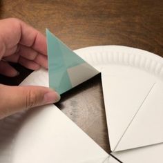 someone is making a paper plate with an origami triangle