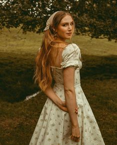 a woman with long red hair wearing a white dress