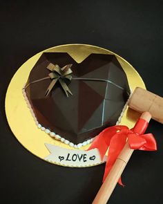 a heart shaped chocolate cake on top of a yellow plate next to a wooden rolling pin