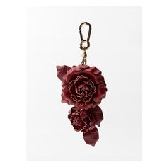 a red flower is hanging from a key chain