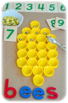 a table topped with lots of yellow cups and numbers