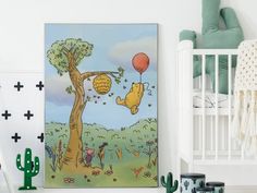 winnie the pooh nursery art print hanging on a wall next to a crib