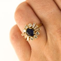 Here is a 18K Yellow Gold ring with a centre Sapphire and in the Gallery there are 6 Round Diamonds and 6 Tapered Baguette Diamonds. Condition: Used (Very Good) Weight: 3.8 grams UK Ring Size: J Please contact for quick resizing! Tested as: 18K Yellow Gold Box: New Gift Box Comments: These Diamonds/Gemstones have not been certified by a laboratory, they have been graded by our own qualified gemologists as fairly and as accurately as possible. Postage: This Ring will be posted via Royal Mail Special Delivery, and should be with you within 3 days of your order. Free postage to the UK! We are a trusted company in Hatton Gardens London, with a wide range stock of high-end watches and fine jewellery. Have a look at our other listings or message us any interest in any item you may be looking for Yellow Gold Cluster Ring With Cubic Zirconia, Yellow Gold Cluster Jewelry With Halo Setting, Heirloom Yellow Gold Baguette Cut Cluster Ring, Yellow Gold Cluster Ring With 17 Jewels, Cluster Yellow Gold Sapphire Ring, Cluster Sapphire Ring In Yellow Gold, Gold Cluster Ring With Baguette Cut And Prong Setting, Yellow Gold Cluster Sapphire Ring, Yellow Gold Sapphire Cluster Ring