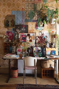 a desk with plants and pictures on the wall