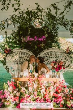 two people sitting at a table with flowers and umbrellas over them that say, where to meet