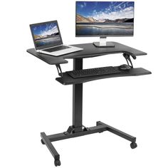 a laptop computer sitting on top of a standing desk with a monitor and keyboard in front of it