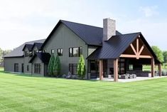 a large gray house sitting on top of a lush green field