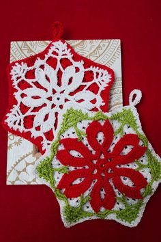 two crocheted christmas ornaments on a red background