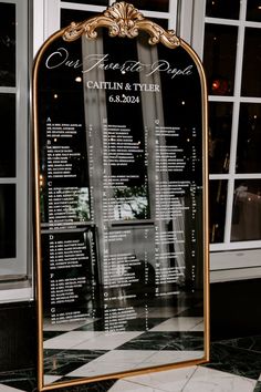 the seating chart for an event is displayed in front of a large mirror with gold trim