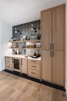 a kitchen with wooden cabinets and white counter tops on top of a hard wood floor