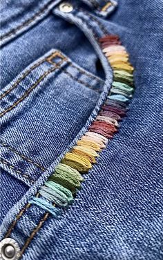 the back pocket of a pair of jeans with colorful stitchs on it, showing how to sew