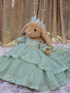 a stuffed rabbit dressed in a green dress