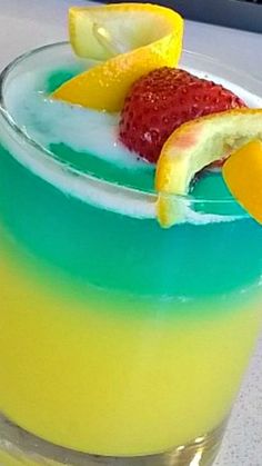 a colorful drink with lemons and strawberries on the rim