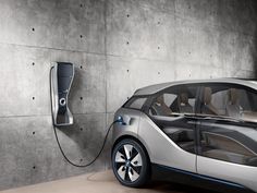 an electric car plugged in to a concrete wall