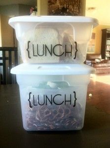 two plastic containers sitting on top of a table with lunch written on the side of them