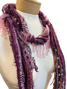 These beaded scarf necklaces are made with Italian silk yarns and mohair and other yarns. A great accent for your summer wardrobe. They are lightweight and comfortable to wear. Measuring 48 inches in length. Colors are a mix of pink and purple. Makes a great addition to any wardrobe, adding that needed splash of color!Comes in a linen pouch Purple Bohemian Scarf, One Size, Purple Bohemian Scarf One Size, Bohemian Purple Scarf One Size, One Size Purple Bohemian Scarf, One Size Bohemian Purple Scarf, Handmade Bohemian Yarn Scarves, Handmade Yarn Bohemian Scarves, Handmade Bohemian Yarn Scarf, Scarf Necklaces