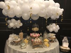 a table topped with white balloons and desserts