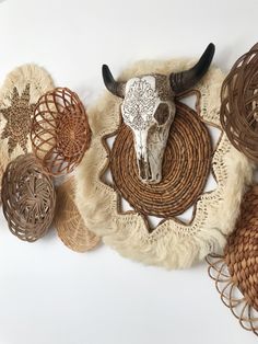 a cow skull is on top of some woven baskets and other items in the shape of animals'heads