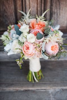 a bridal bouquet with peach and white flowers